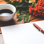 Cup of coffee with a pen and a blank piece of paper